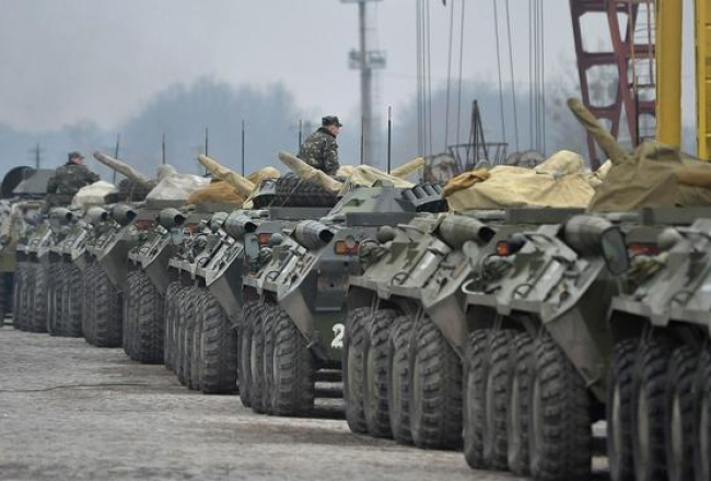 Ukrainas armijas bruņumašīnas sastājušās līnijā Ļvovā, lai tiktu transportētas. Foto: EPA/LETA