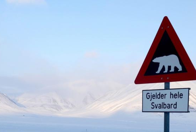 Ziemeļpola tuvumā Svalbardā, Norvēģijā, ceļa zīme rāda, ka jāuzmanās no leduslāčiem. Foto: AFP/LETA