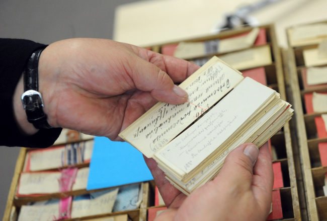 Dainu skapja atvilknes ar latviešu folklorista Krišjāņa Barona savāktajām latviešu tautasdziesmu kartēm Latvijas Nacionālo bibliotēkas ēkā "Gaismas pils". Foto: Ieva Lūka, LETA
