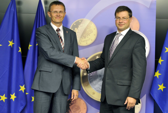 Finanšu ministrs Andris Vilks (no kreisās) un valdības vadītājs Valdis Dombrovskis pozē Briselē pēc paziņojuma par eiro ieviešanu Latvijā. Foto: AFP/LETA