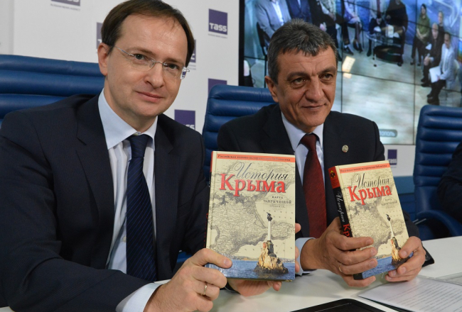 Krievijas kultūras ministrs Vladimirs Medinskis (no kreisās) un okupētās Sevastopoles gubernators Sergejs Meņailo ar pārrakstīto Krimas vēstures grāmatu. Foto: ITAR-TASS/LETA