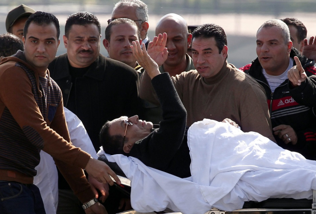 Bijušais Ēģiptes prezidents Hosni Mubaraks nestuvēs sveicina sagaidītājus. Foto: AFP/LETA
