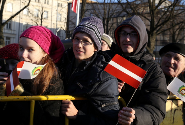 Cilvēki valsts svētku parādē Daugavmalā. Foto: Evija Trifanova, LETA