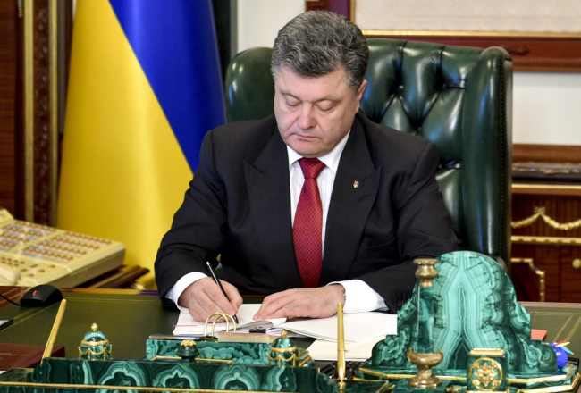 Ukrainas prezidents Petro Porošenko paraksta lustrācijas likumu. Foto: EPA/LETA