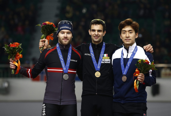Uzvarētājs itālis Andrea Džovannīni (centrā), sudraba medaļnieks latvietis Haralds Silovs (no kreisās) un trešo vietu izcīnījušais Dienvidkorejas sportists Lī Sjunghuns uz goda pjedestāla pēc Pasaules kausa otrā posma sacensībām Seulā distancē ar masu startu. Foto: EPA/LETA