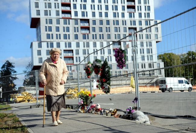 Sieviete pie Zolitūdes sagruvušā lielveikala "Maxima" ēkas, kur notiek virszemes daļu un teritorijas sakopšanas darbi. Foto: Edijs Pālens, LETA