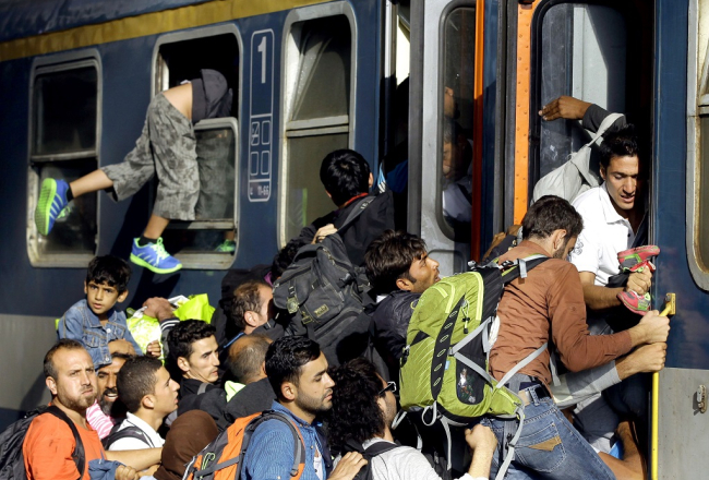 Sīriešu bēgļi laužas vilcienā, kam jādodas uz Austriju, Budapeštas dzelzceļa stacijā. Foto: AFP/LETA