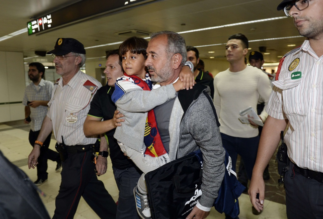 Sīrijas bēgli Osamu Abdulu Mohasenu al Ghadabu un viņa dēlu Zaidu Barselonas dzelzceļa stacijā sagaida Spānijas imigrācijas dienesta pārstāvji. Foto: AFP/LETA