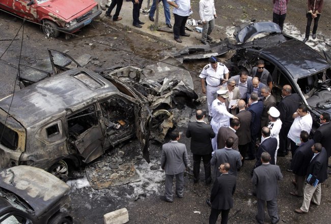 Izmeklētāji pēta vietu, kur tika uzspridzināta Ēģiptes ģenerālprokurora automašīna. Foto: EPA/LETA