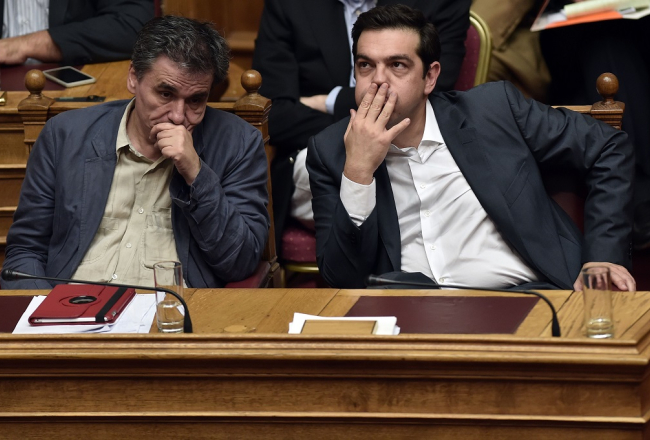 Grieķijas premjerministrs Aleksis Ciprs (no labās) un finanšu ministrs Eiklīds Cakalots parlamenta sēdē. Foto: AFP/LETA