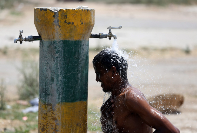 Strādnieks Indijā atvēsinās. Foto: EPA/LETA