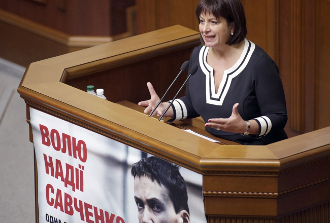 Ukrainas finanšu ministre Natālija Jaresko uzstājas parlamentā. Tribīnei piestiprināts plakāts, kas aicina atbrīvot Ukrainas lidotāju Nadeždu Savčenko. Foto: AFP/LETA