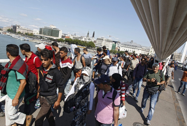 Migranti Budapeštā pāri Donavas tiltam dodas Austrijas virzienā. Foto: AFP/LETA