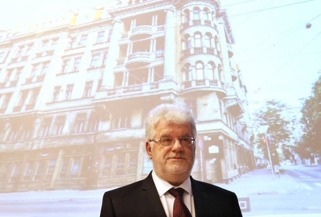 Okupācijas muzeja vadītājs Gunārs Nāgels pie attēla ar bijušo čekas jeb Stūra māju. Foto: Kaspars Krafts, F64