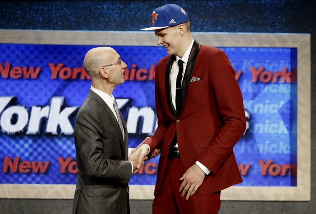 Latviešu basketbolists Kristaps Porziņģis (no labās) Nacionālās basketbola asociācijas (NBA) drafta ceremonijā pasniedz roku līgas komisāram Adamam Silveram. Foto: EPA/LETA