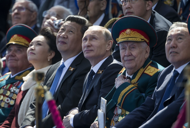 Krievijas prezidents Vladimirs Putins (centrā) parādes laikā ar saviem atbalstītājiem - Ķīnas prezidentu Sji Dzjiņpinu (pa kreisi no Putina) un Kazahstānas prezidentu Nursultanu Nazarbajevu (no labās). Foto: AFP/LETA