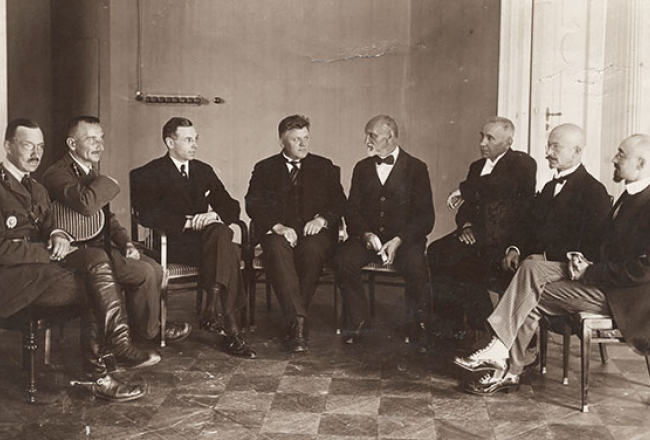 Rainis diplomāts — ar Latvijas delegācijas dalībniekiem 1920.gada Baltijas valstu konferencē Bulduros. No kreisās: K.Ramats, P.Radziņš, Zigfrīds Anna Meierovics, Kārlis Ulmanis, Rainis, K.Kasparsons, V.Zāmuels, H.Albats.