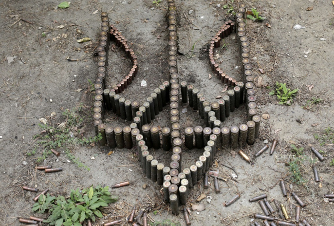 Ukrainas ģerboni no ložu čaulītēm izveidojuši karavīri, kas atrodas pozīcijās pie Krimskas. Foto: AFP/LETA