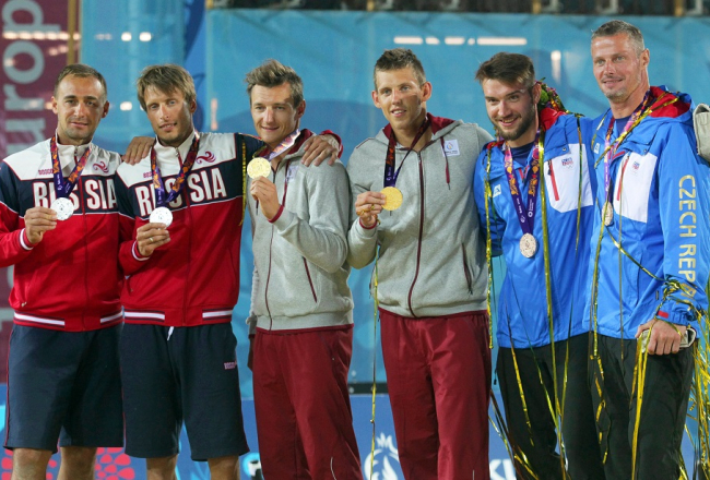 Mārtiņš Pļaviņš (trešais no kreisās) un Haralds Regža uz goda pjedestāla Baku spēlēs kopā ar otrās vietas ieguvējiem no Krievijas Dmitriju Barsuku un Jaroslavu Koškarevu, kā arī bronzas medaļu ieguvējiem čehiem Janu Hadravu un Premislu Kubalu. Foto: EPA/LETA