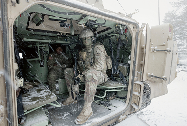 Metjū Buhanans kaujasmašīnā M2A3 Bradley. Izlūki to lieto mazā izmēra dēļ. Bradley aprīkots ar diviem šaujamajiem: 25 milimetru un rotējošu 7,62. Tam ir nakts redzamība un termosensors, kas var uztvert tuvumā esošu cilvēku. Bradley var pārvadāt deviņus cilvēkus. Latvijā ir sešas šādas kaujas mašīnas.