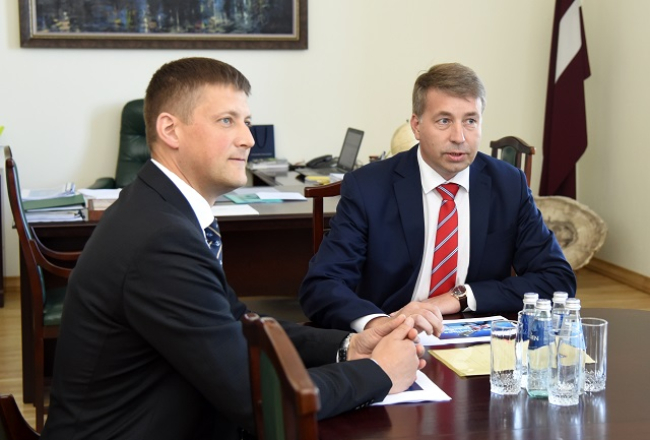 Krievijas transporta ministrs Maksims Sokolovs (no kreisās) un Starpvaldību komisijas līdzpriekšsēdētājs, Latvijas satiksmes ministrs Uldis Augulis. Viņiem priekšā tikai krievu valodā rakstītas vārdu kartes.