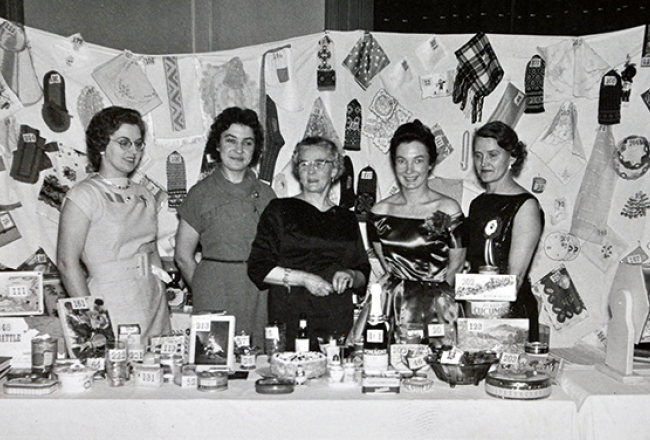 1958. gads, Bredfordas Daugavas vanadžu komiteja pie gadskārtējās loterijas galda, kurā varēja vinnēt arī pašu darinātus gardumus un tautiskus rokdarbus