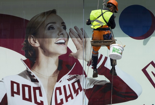 Krievijas sportiste Tatjana Navka tērpusies olimpiskās izlases apģērbā lielā plakātā Krievijas olimpiskās komitejas logā. Foto: AP/LETA
