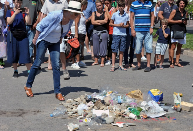 Vietā, kur Nicas promenādē tika nogalināts terorists, cilvēki liek akmeņus un atkritumus, nevis ziedus. Foto: Reuters/LETA