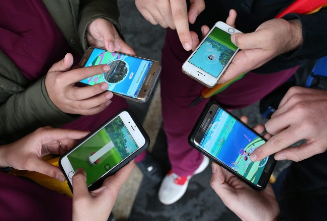 "Pokemon Go" spēlētāji pie Sidnejas operas. Foto: EPA/LETA