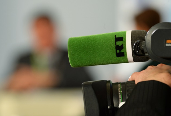 "Russia Today" logo uz mikrofona. Foto: Sputnik/LETA