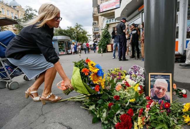 Cilvēki Kijevā liek ziedus vietā, kur tika nogalināts žurnālists Pāvels Šeremets. Foto: EPA/LETA