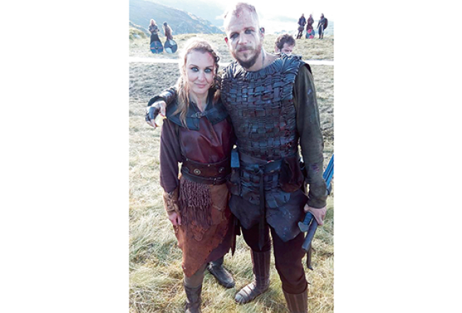 Īrijā dzīvojošā latviete Kristīne Ķēniņa kanādiešu seriālā Vikingi redzama 3. un 4.sezonā kā fona aktrise. Seriālā kopumā filmējušies seši latvieši. Attēlā: ar zviedru aktieri Gustavu Skarsgārdu.