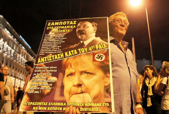 Grieķijas taupības pasākumu pretinieki protestē pirms Vācijas kancleres Angelas Merkeles vizītes Atēnās. «Nepērciet vācu preces. Pretojieties Ceturtajam reiham.»