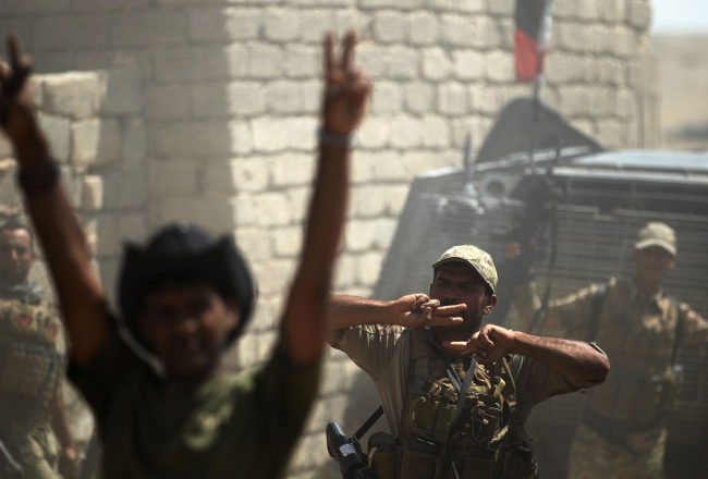 Irākas karavīri priecājas par džihādistiem atgūto Tell Afaras pilsētu. Foto: AFP/LETA