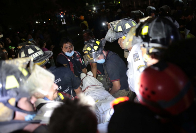 Glābēji pēc zemestrīces no drupām izceļ mirušos. Foto: AFP/LETA