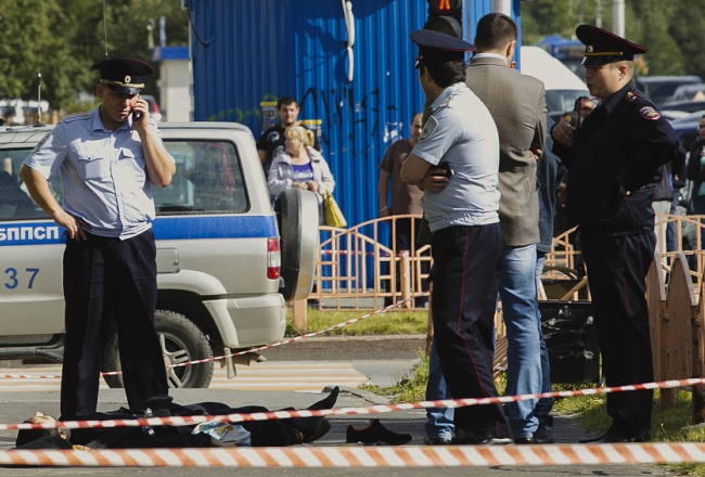 Krievijas policisti Surgutā pie uzbrukuma upura. Foto: LETA/AP