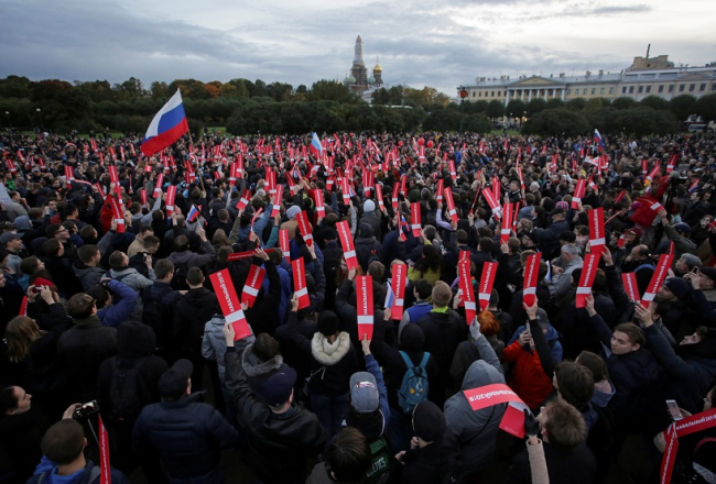 Protestētāji pret Vladimiru Putinu un opozicionāra Alekseja Navļnija atbalstītāji pulcējas gājienam Sanktpēterburgā. Foto: Reuters/LETA