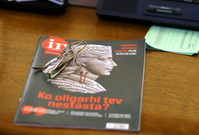 Žurnāla "Ir" speciālizdevums par oligarhu lietu uz Saeimas deputāta darba galda ārkārtas sēdē, kurā lēma par parlamentārās izmeklēšanas komisijas sastāvu. Foto: Edijs Pālens, LETA