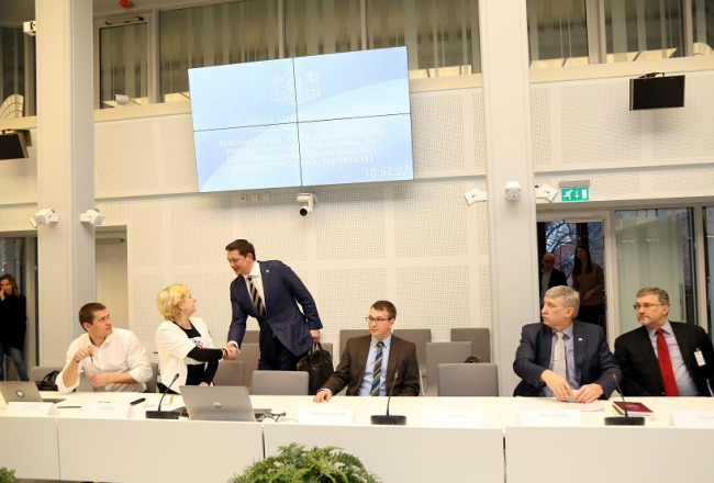 Oligarhu lietas Saeimas parlamentārās izmeklēšanas komisijā deputāts Artuss Kaimiņš sarokojas ar bijušo KNAB darbinieci Jutu Strīķi un Juris Jurašu. Pa labi - Jaroslavs Streļčenoks, Ēriks Kalnmeiers un Juris Leitietis. Foto: Edijs Pālens, LETA