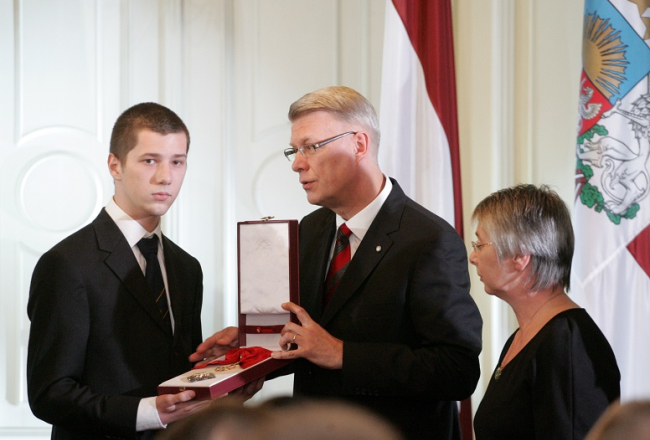 Valsts prezidents Valdis Zatlers (centrā) pasniedz Viestura ordeni par izrādīto drosmi un varonību, piedaloties Latvijas valsts neatkarības aizstāvēšanā 1991.gada janvāra barikāžu laikā kinooperatora, barikāžu dalībnieka Andra Slapiņa tuviniekiem. Pa kreisi - Slapiņa dēls Andris. Foto: Ieva Čīka, LETA