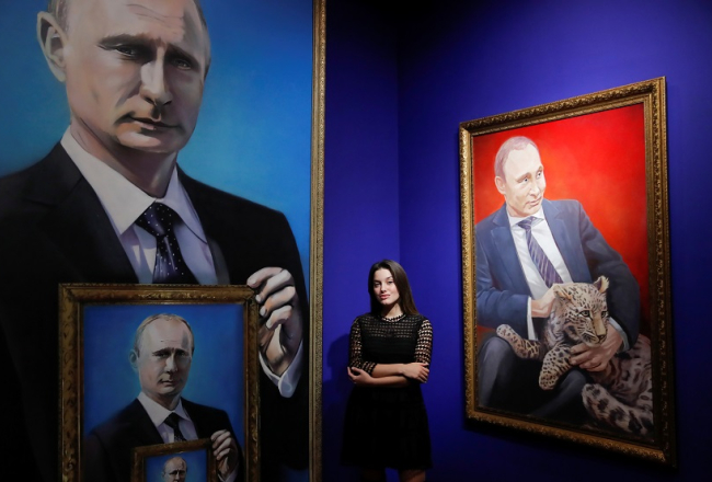 Studente Jūlija Družņeva ir Putina atbalstītāja un pozē pie pašas vadītās izstādes "Superputins" darbiem. Foto: Reuters/LETA