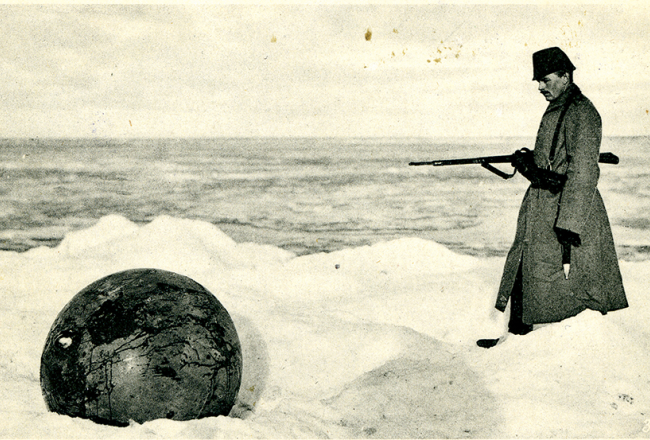 Vācu karavīrs pie Kurzemes krastā izskalotas jūras mīnas.
Foto no Latvijas Kara muzeja krājuma