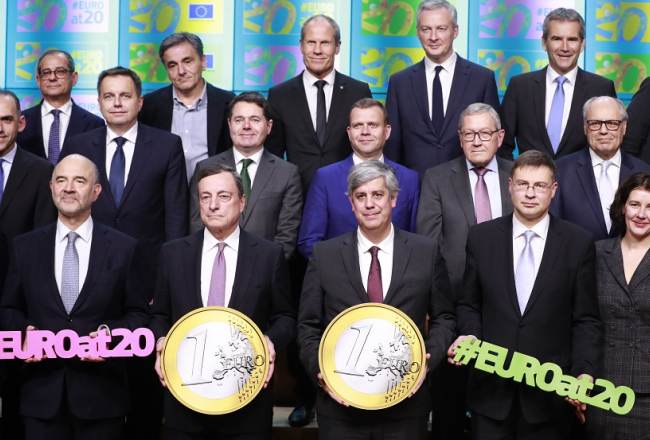 Eirozonas valstu finanšu ministri kopīgā foto Briselē 3.decembrī ar ECB prezidentu Mario Dragi (centrā). Pirmajā rindā no labās - Latvijas finanšu ministre Dana Reizniece-Ozola un EK viceprezidents Valdis Dombrovskis. Foto: EPA/Scanpix