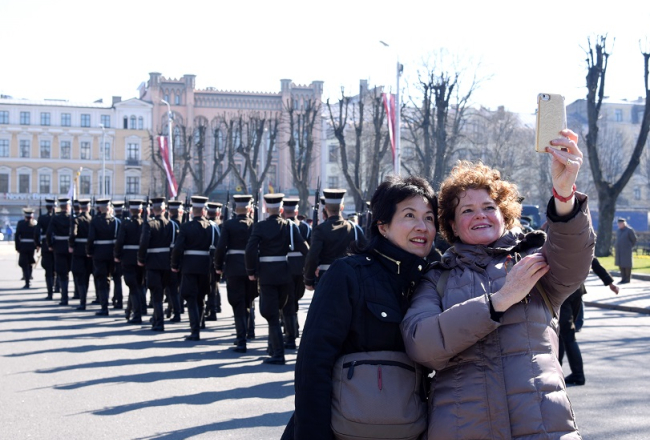 Tūristi fotografējas pie Brīvības pieminekļa. Foto: Zane Bitere, LETA