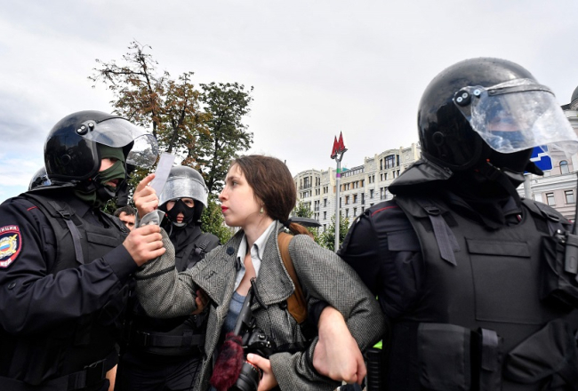Omonieši Maskavā aiztur kādu protestētāju. Foto: AFP/Scanpix