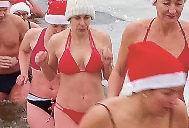 Ziemas peldētāja Gunita Nagle (baltajā cepurītē) nāk laukā no Lielupes.
Foto no privātā arhīva