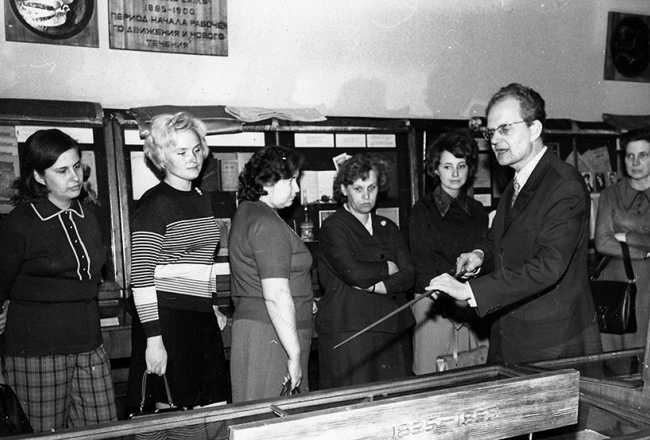 Aleksejs Apīnis atklāj ekspozīciju Latviešu grāmatniecības vēsture Reto grāmatu un rokrakstu nodaļā. 1975. gads. Fotogrāfs nezināms. Latvijas Nacionālās bibliotēkas krājums