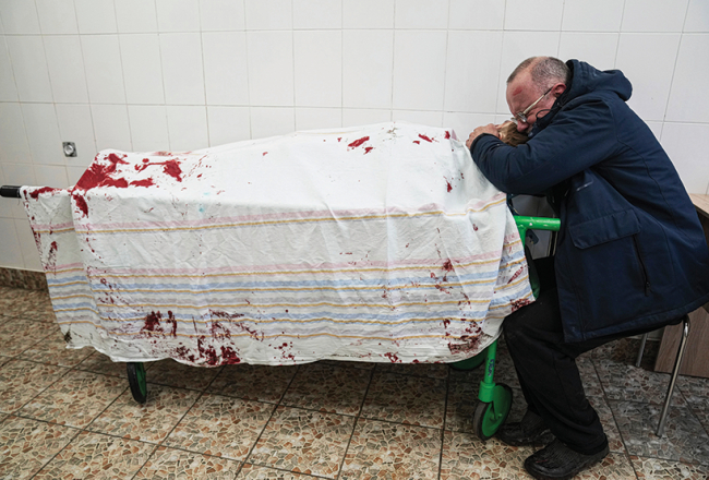 Pusaudža Iļjas tēvs Serhijs pie sava bombardēšanā bojā gājušā dēla Mariupolē.
Foto — Scanpix