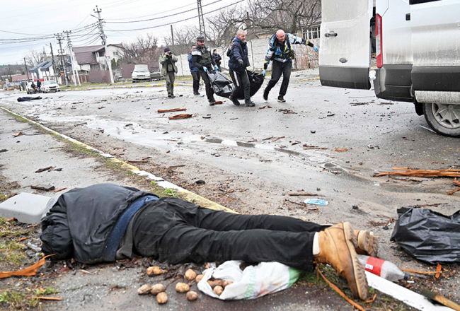 Komunālo dienestu darbinieki savāc nogalināto civiliedzīvotāju līķus Bučas pilsētā 3. aprīlī.
Foto — Scanpix