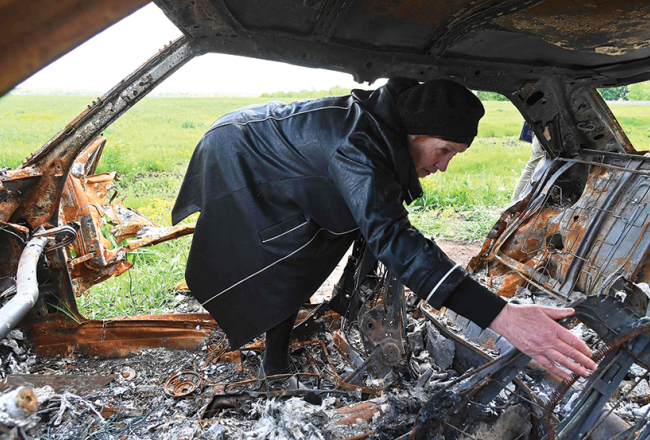 Olga Homenko (67) skatās uz sava 38 gadus vecā dēla mirstīgajām atliekām, pēc tam kad viņa automašīnai Malaroganas ciemā netālu no Harkivas trāpīja krievu tanka raidīts šāviņš.
Foto — Scanpix